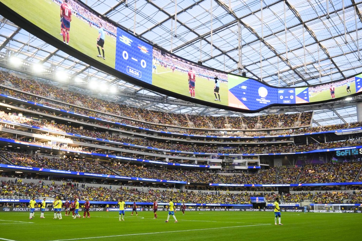 Soccer fans waving flags outside a massive modern US stadium during World Cup matches